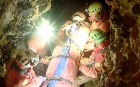 Auf einer Trage musste die verunglückte Forscherin durch die engen Höhlengänge getragen werden. - Foto: -/Italienische Bergrettung/dpa