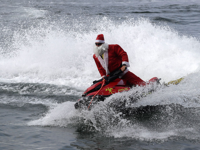 Für die Kinder gab es Geschenke vom Jetski aus. - Foto: Bruna Prado/AP Photo/dpa