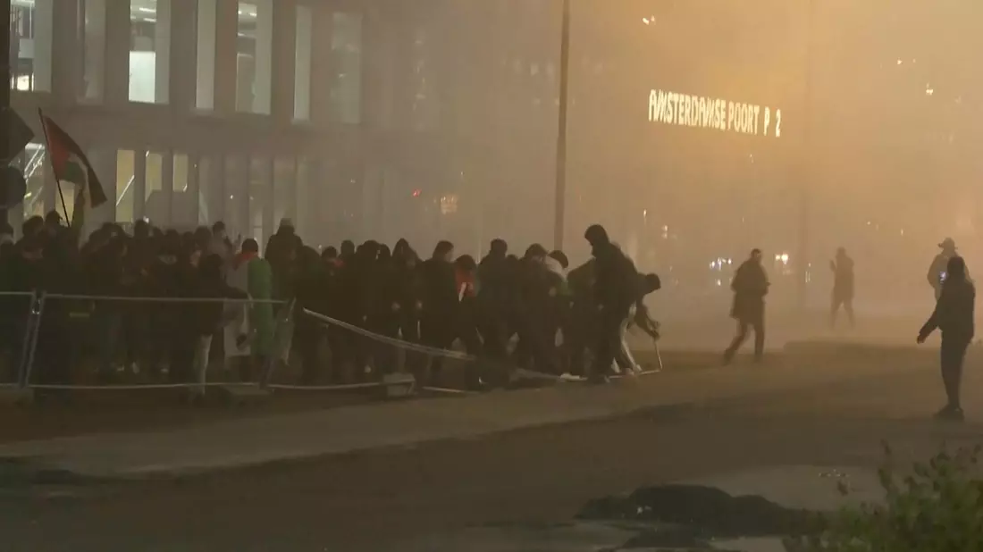 In diesem Videostandbild werfen pro-palästinensische Demonstranten eine Metallbarriere in der Nähe des Fußballstadions in Amsterdam um. (Archiv) - Bild: RTL Nieuws/RTL Nieuws/AP/dpa