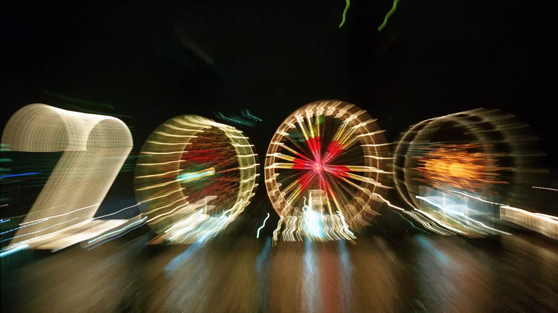 25 Jahre alt ist dieses «2000»-Foto: Ein Zoom-Effekt verfremdet eine große «2» und drei Riesenräder am Mainufer in Frankfurt in der Silvesternacht 1999/2000.  - Bild: Arne Dedert/dpa