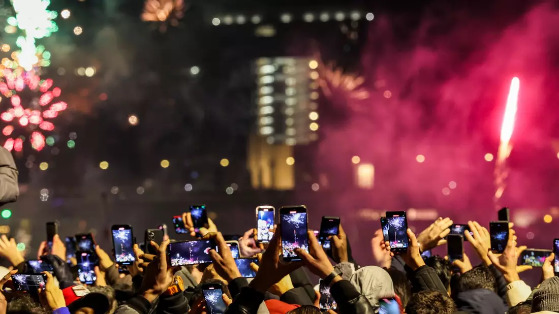 Silvester in Düsseldorf - und Tausende Menschen am Rheinufer filmen mit. - Bild: Christoph Reichwein/dpa