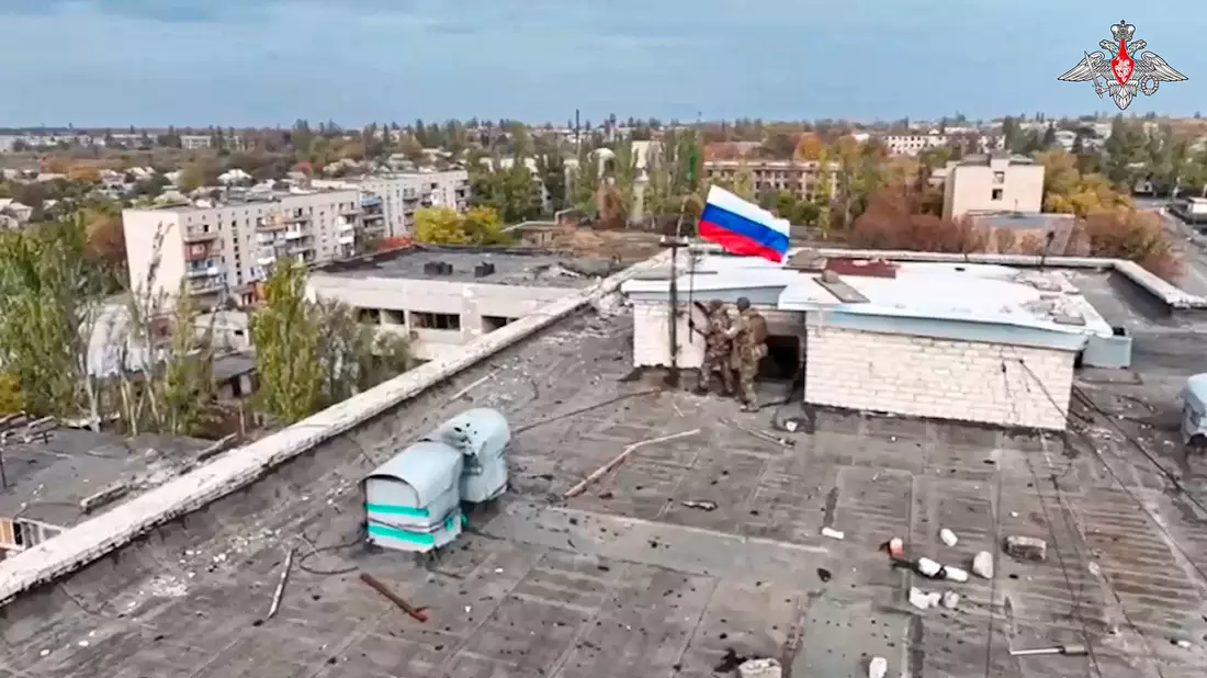 Russische Soldaten hissen in einer Ortschaft auf einem Gebäude eine Fahne nach dessen Einnahme. (Archivbild/Handout)  - Bild: Uncredited/Russian Defense Ministry Press Service/AP/dpa