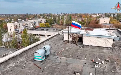 Russische Soldaten hissen in einer Ortschaft auf einem Gebäude eine Fahne nach dessen Einnahme. (Archivbild/Handout)  - Foto: Uncredited/Russian Defense Ministry Press Service/AP/dpa