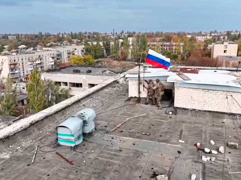 Russische Soldaten hissen in einer Ortschaft auf einem Gebäude eine Fahne nach dessen Einnahme. (Archivbild/Handout)  - Foto: Uncredited/Russian Defense Ministry Press Service/AP/dpa