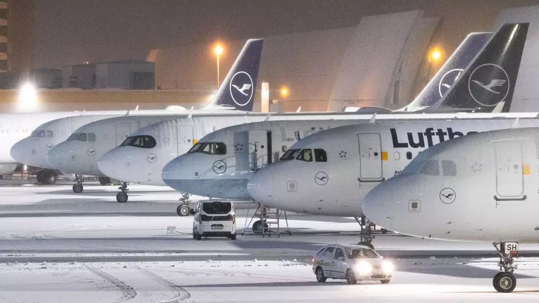 Mit Schnee bedeckte Flugzeuge auf dem Flughafen Frankfurt. Wegen Schnee und Eisregen sind hier 120 Flüge annulliert worden. - Bild: Lando Hass/dpa