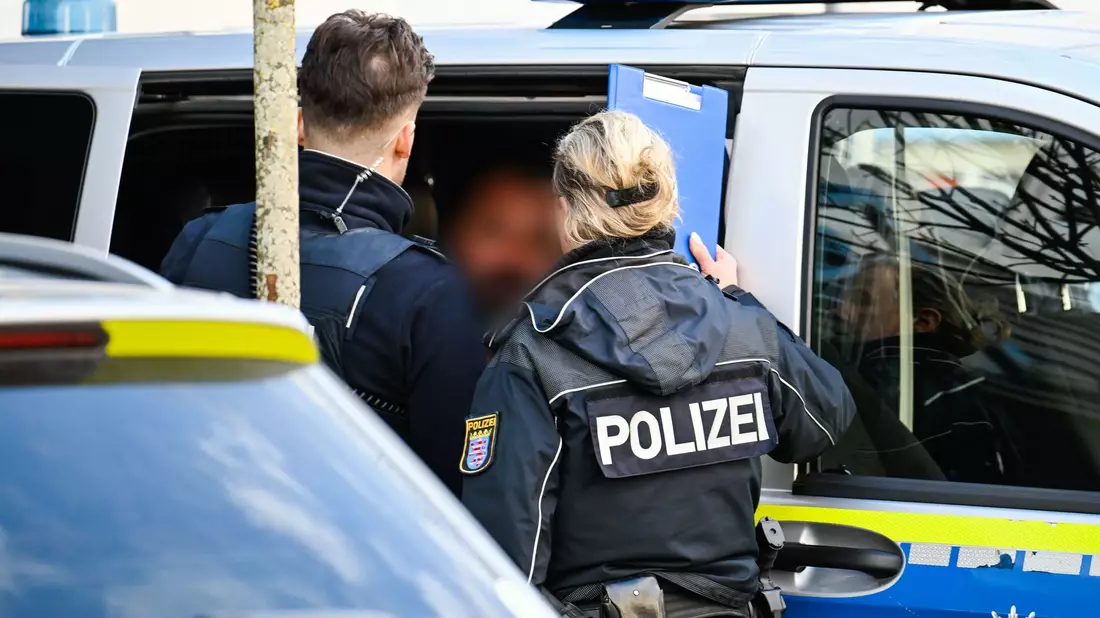 Der mutmaßliche Täter wurde nach der Festnahme in ein Polizeiauto gebracht. - Bild: Uwe Anspach/dpa