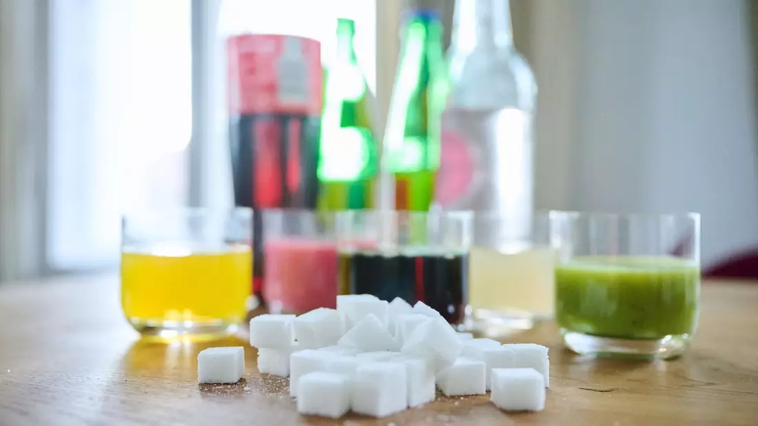 Zwei unterschiedliche Arten Softdrinks mit Eiswürfeln stehen auf einem Tisch - Bild: Annette Riedl/dpa