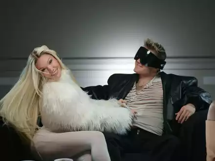 Shirin David und Ski Aggu sitzen auf einem Sofa bei einem Fototermin für ihren Song «Atzen & Barbies» - Foto: -/Universal Music GmbH/dpa