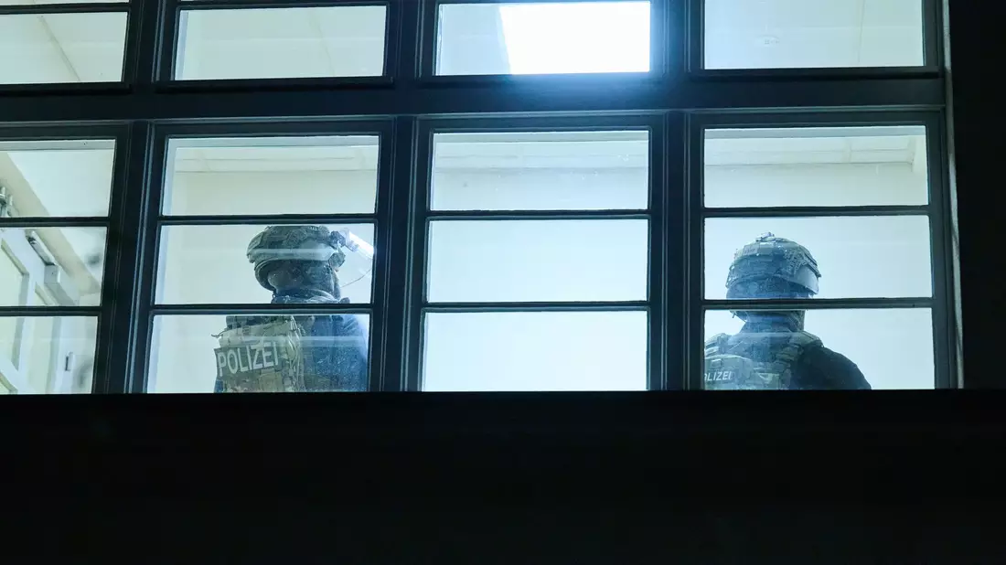 Schwerbewaffnete Polizisten durchsuchen eine Grundschule in Berlin. Doch am Abend kommt Entwarnung. - Bild: Annette Riedl/dpa