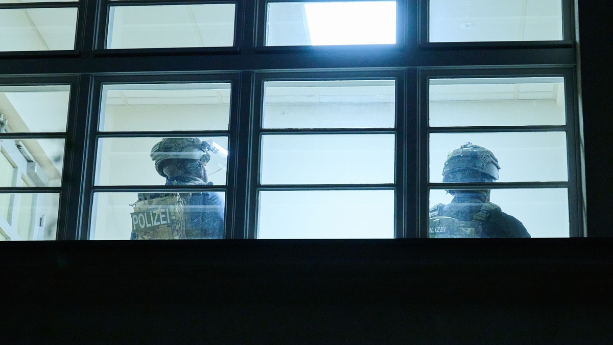 Schwerbewaffnete Polizisten durchsuchen eine Grundschule in Berlin. Doch am Abend kommt Entwarnung. - Foto: Annette Riedl/dpa