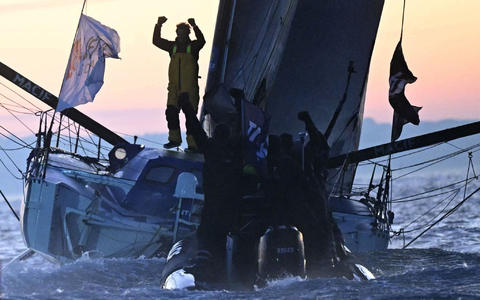 Geschafft: Charlie Dalin bejubelt seinen Sieg.   - Foto: Loic Venance/AFP/dpa