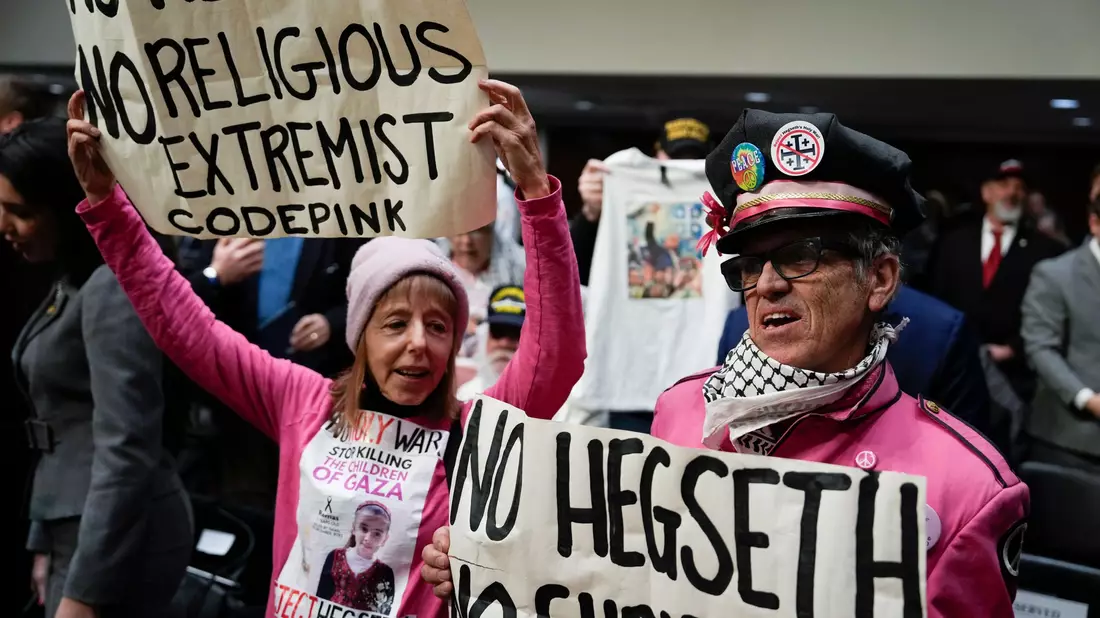Die Gruppe «Code Pink» gehört zu jenen, die gegen Hegseths Nominierung protestieren. - Bild: Ben Curtis/AP/dpa