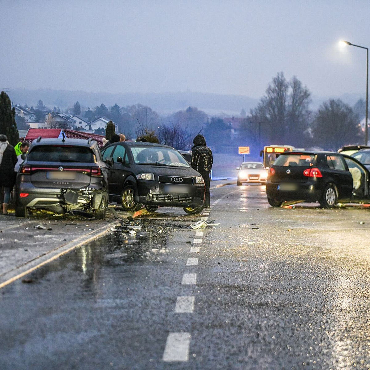 Nach einem Unfall bei Glatteis mit mehreren Fahrzeugen in Baden-Württemberg stehen Helfer und Beteiligte an den Autos auf einer Straße.  - Foto: Jason Tschepljakow/dpa