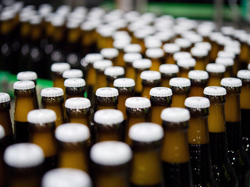 Bierflaschen mit Kronkorken laufen durch die Produktion der Veltins-Brauerei in Meschede-Grevenstein über die Förderbänder einer Befüllungsanlage. - Foto: Rainer Jensen/dpa