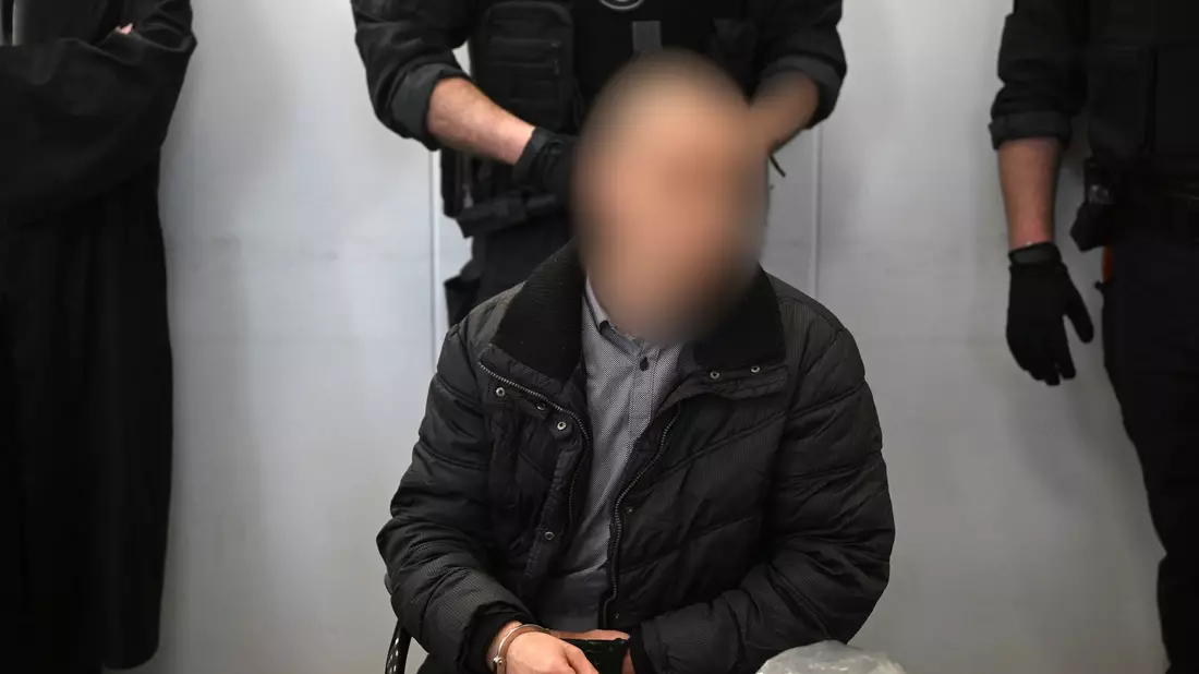 Der wegen Mordes an der neunjährigen Valeriia Angeklagte wird im Landgericht Chemnitz von einem Justizmitarbeiter vorgeführt. - Bild: Hendrik Schmidt/dpa