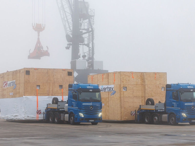 Verpackt in riesigen Holzkisten werden die Teile des Teleskops in Wesel auf ein Schiff geladen. - Foto: Christoph Reichwein/dpa
