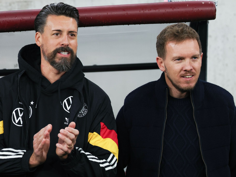 Sandro Wagner (l) will mindestens bis zur WM 2026 an der Seite von Julian Nagelsmann bleiben. - Foto: Christian Charisius/dpa