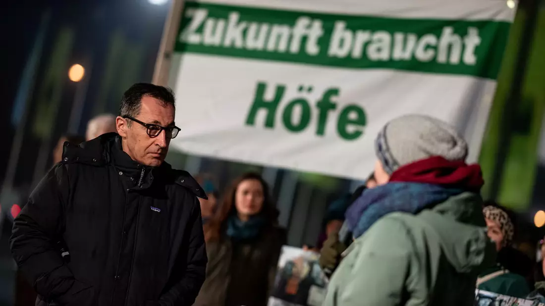 Bundeslandwirtschaftsminister Cem Özdemir hört sich an, was Aktivisten bei der Grünen Woche fordern.  - Bild: Fabian Sommer/dpa