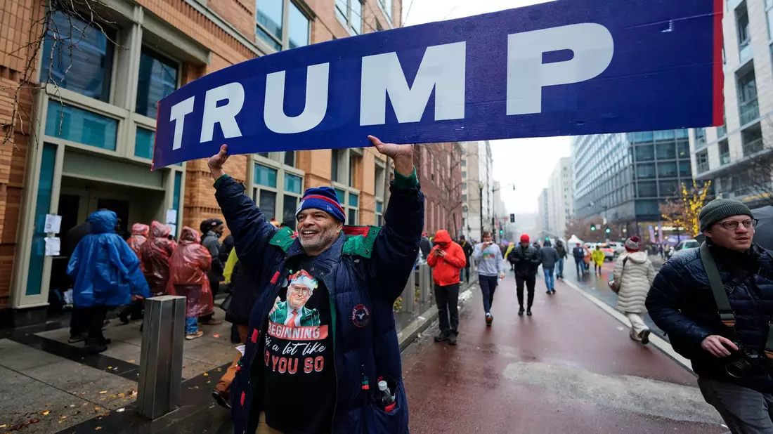 Dieser Straßenverkäufer wird vor der Arena, in der Trump später spricht, einiges an Merchandise-Artikeln los. - Bild: Mike Stewart/AP/dpa