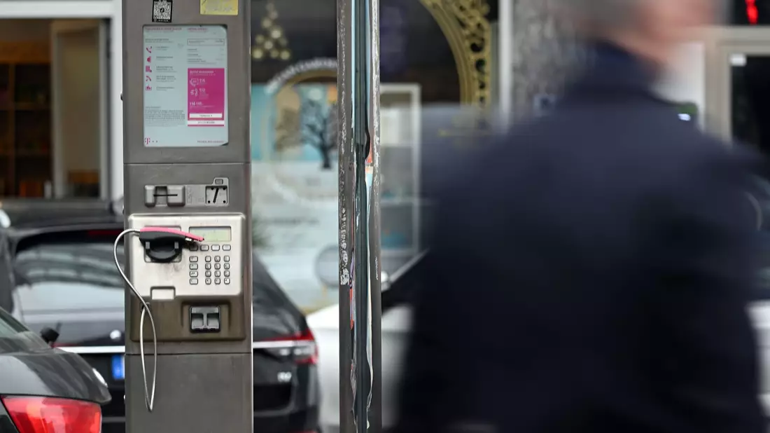 Ein abgebrochener Telefonhörer liegt in der Halterung eines deaktivierten Fernsprechers. - Bild: Federico Gambarini/dpa