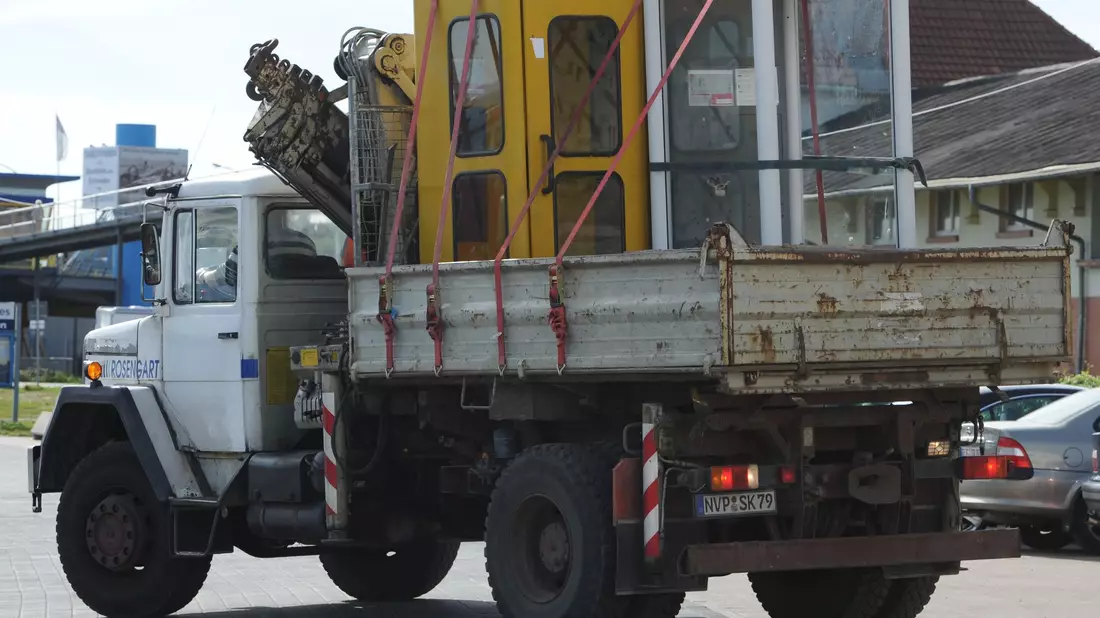 Der Abbau läuft schon seit langem: Hier werden in Sassnitz (Mecklenburg-Vorpommern) im Jahr 2010 zwei Telefonhäuschen zur Entsorgung abtransportiert. (Archivbild) - Bild: picture alliance / dpa