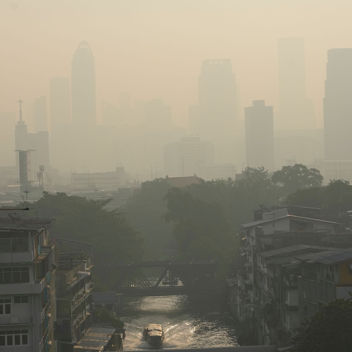 Pendler tragen Gesichtsmasken, um sich vor der Luftverschmutzung zu schützen. - Foto: Sakchai Lalit/AP/dpa