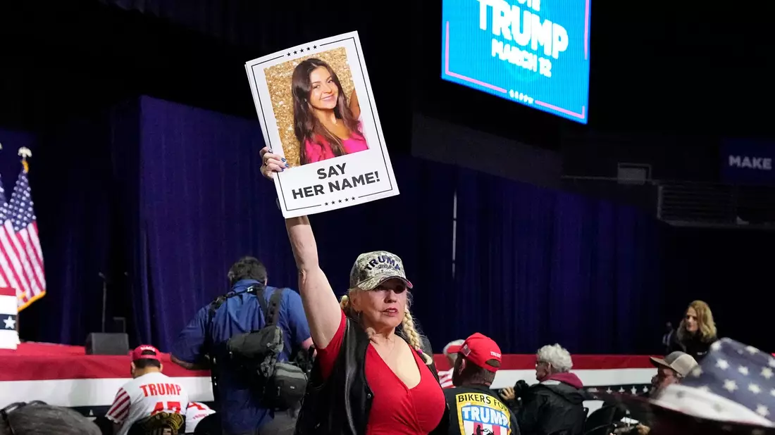 Eine Trump-Unterstützerin hält bei einer Wahlkampfveranstaltung im Bundesstaate Georgia ein Schild in die Höhe, dass die ermordete Studentin Laken Riley zeigt. (Archivbild) - Bild: Mike Stewart/AP