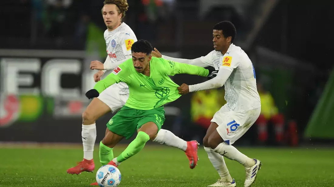 Wolfsburgs Mohamed Amoura (r) spielt gegen Kiels David Zec. - Bild: Swen Pförtner/dpa