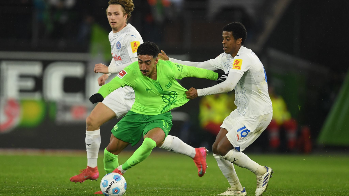 Wolfsburgs Mohamed Amoura (r) spielt gegen Kiels David Zec. - Foto: Swen Pförtner/dpa