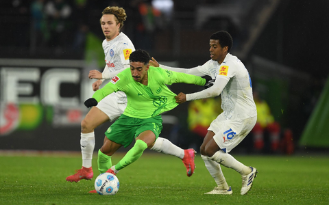 Wolfsburgs Mohamed Amoura (r) spielt gegen Kiels David Zec. - Foto: Swen Pförtner/dpa