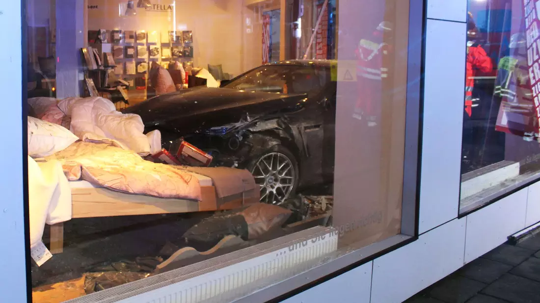 Ein Auto landet bei einem Unfall in Minden im Bettengeschäft.  - Bild: -/Polizei Minden-Lübbecke/dpa
