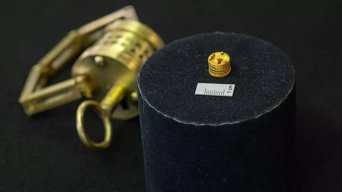 So winzig: Das römische Miniatur-Schloss liegt neben einem Maßstab für einen Zentimeter. Im Hintergrund der Nachbau im Verhältnis 4:1.  - Bild: Guido Kirchner/dpa