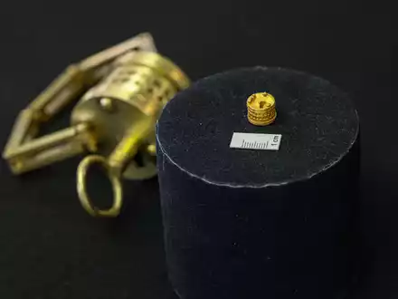 So winzig: Das römische Miniatur-Schloss liegt neben einem Maßstab für einen Zentimeter. Im Hintergrund der Nachbau im Verhältnis 4:1.  - Foto: Guido Kirchner/dpa