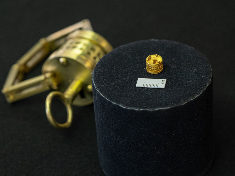 So winzig: Das römische Miniatur-Schloss liegt neben einem Maßstab für einen Zentimeter. Im Hintergrund der Nachbau im Verhältnis 4:1.  - Foto: Guido Kirchner/dpa