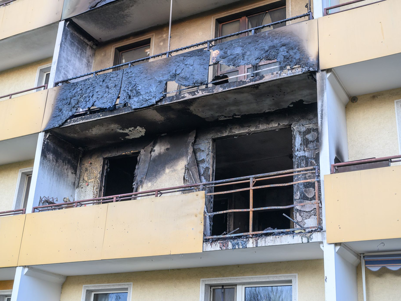 Die Polizei hat den Wohnblock nach dem Brand am Dienstagabend beschlagnahmt und versiegelt.  - Foto: Patrick Pleul/dpa