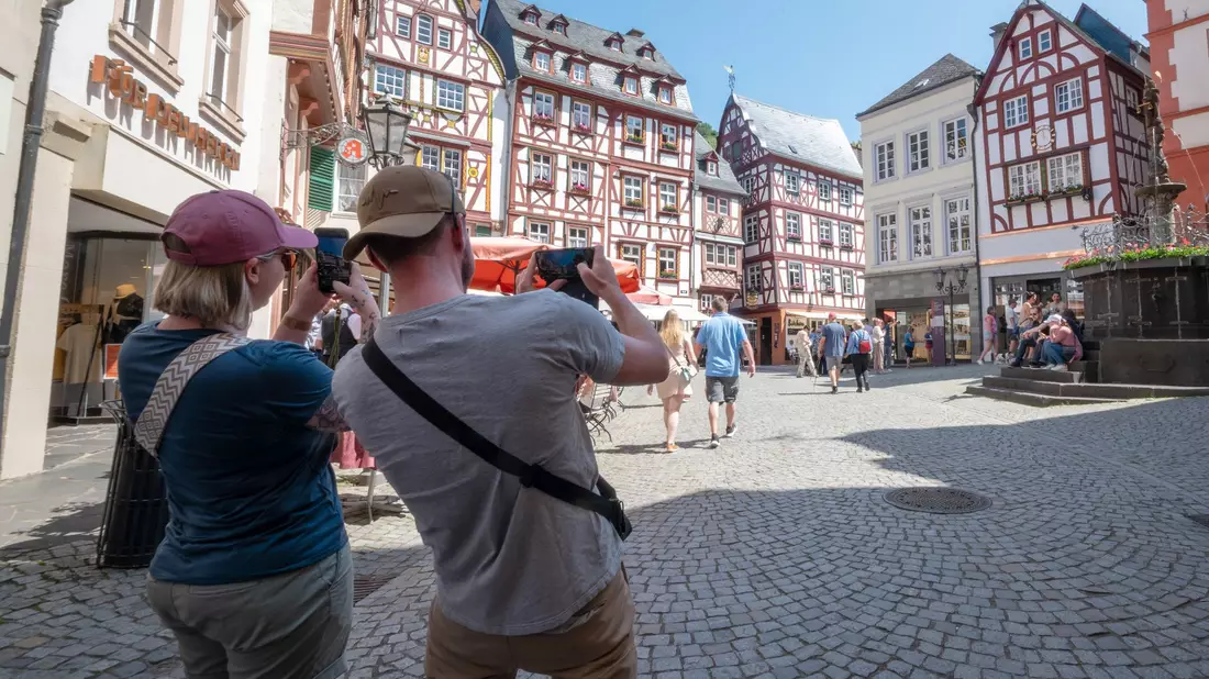 Touristen im Fachwerk-Städtchen Bernkastel-Kues. Die Lust aufs Reisen ist ungebrochen. (Archivbild) - Bild: Harald Tittel/dpa