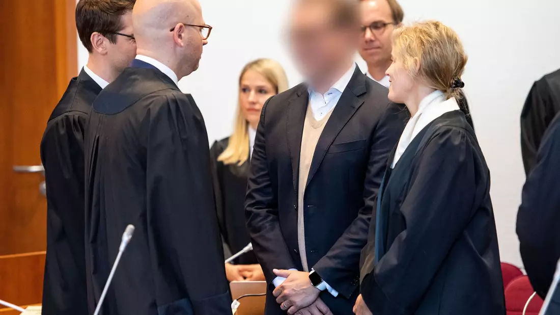 Zum Auftakt des ersten Cum-Ex-Strafprozesses 2019 vor dem Landgericht Bonn steht der Angeklagte (gepixelt) im Gerichtssaal. (Archivbild) - Bild: Marius Becker/dpa