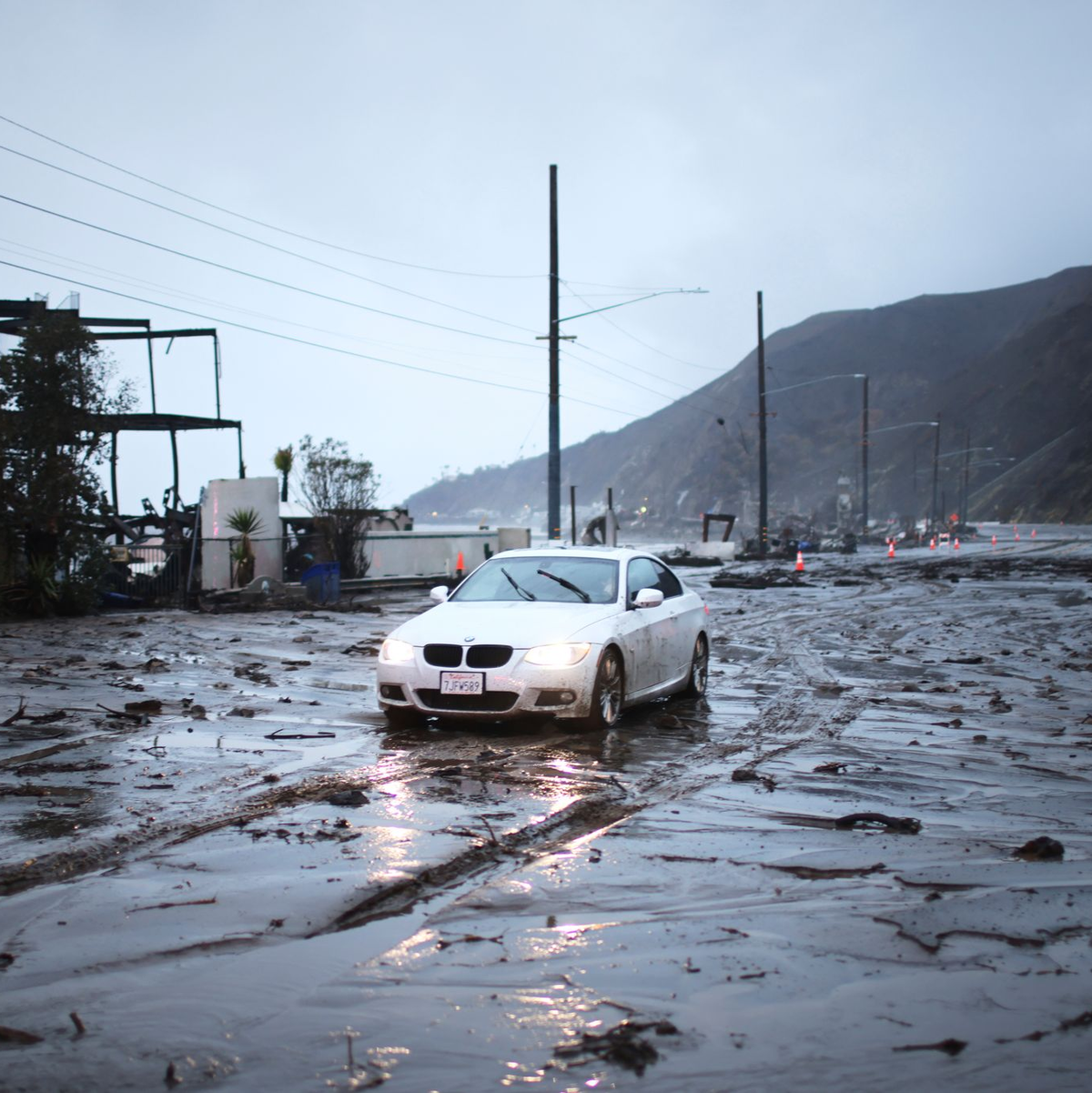 Ein Fahrzeug der Feuerwehr wurde von einer Schlammlawine ins Meer gespült. - Foto: Ethan Swope/AP/dpa