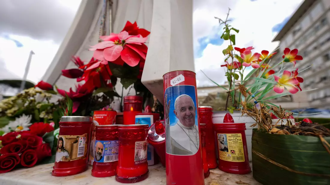 Vor dem Gemelli-Krankenhaus im Rom sind für den erkrankten Papst Franziskus Kerzen aufgestellt. - Bild: Andrew Medichini/AP/dpa
