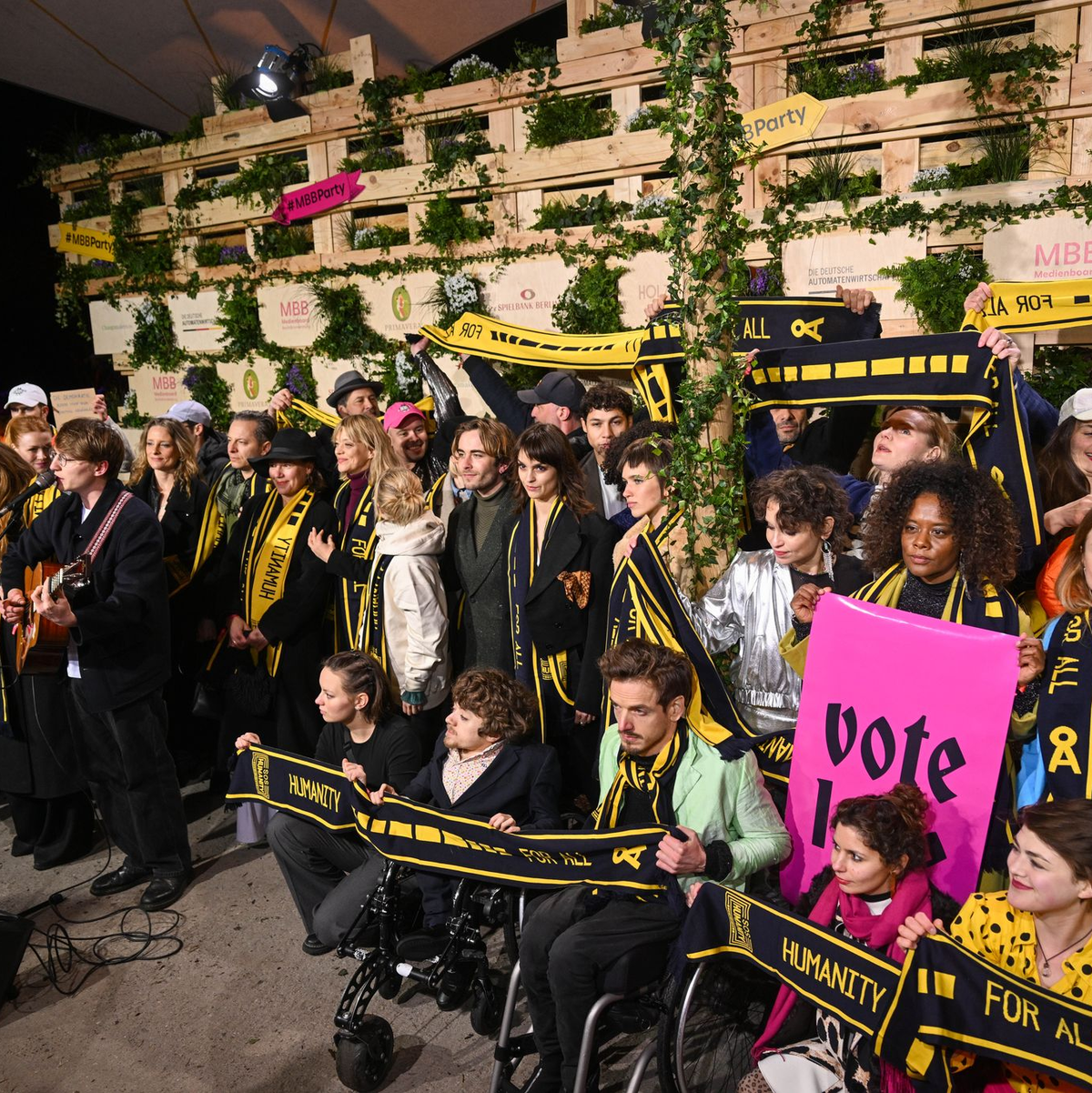 Mit Schals und Schildern haben Prominente an einer Protestaktion von SOS Humanity teilgenommen. - Foto: Christophe Gateau/dpa