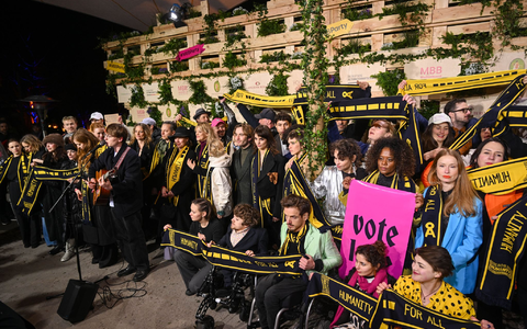 Mit Schals und Schildern haben Prominente an einer Protestaktion von SOS Humanity teilgenommen. - Foto: Christophe Gateau/dpa Mit Schals und Schildern haben Prominente an einer Protestaktion von SOS Humanity teilgenommen. - Foto: Christophe Gateau/dpa