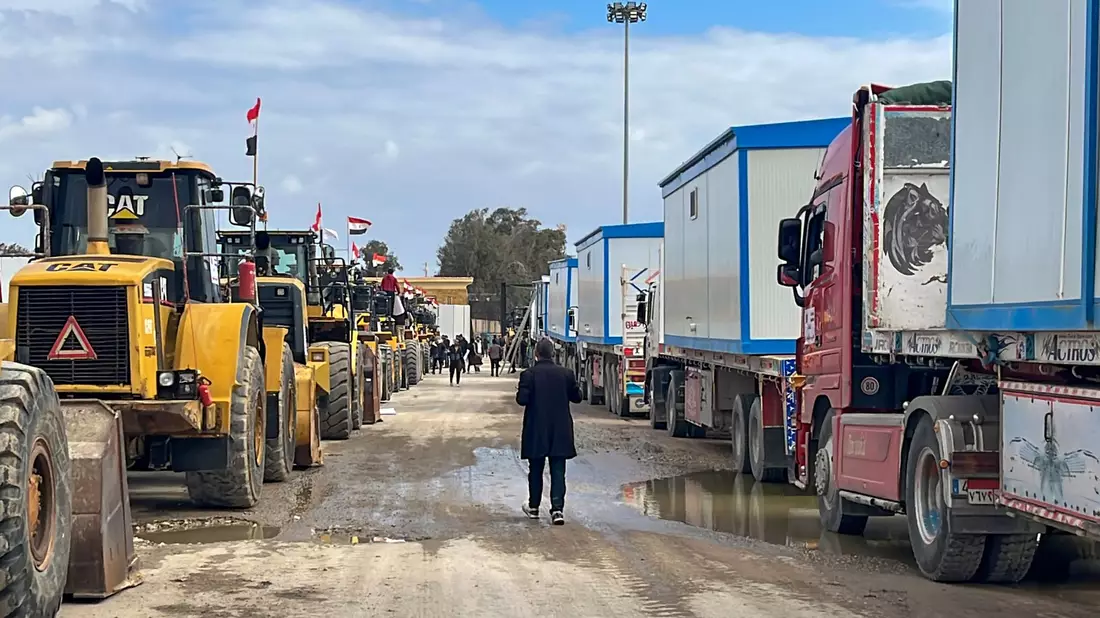 Bulldozer und Lastwagen mit Wohncontainern warten am Rafah-Grenzübergang. (Archivbild) - Bild: Mohamed Arafat/AP/dpa