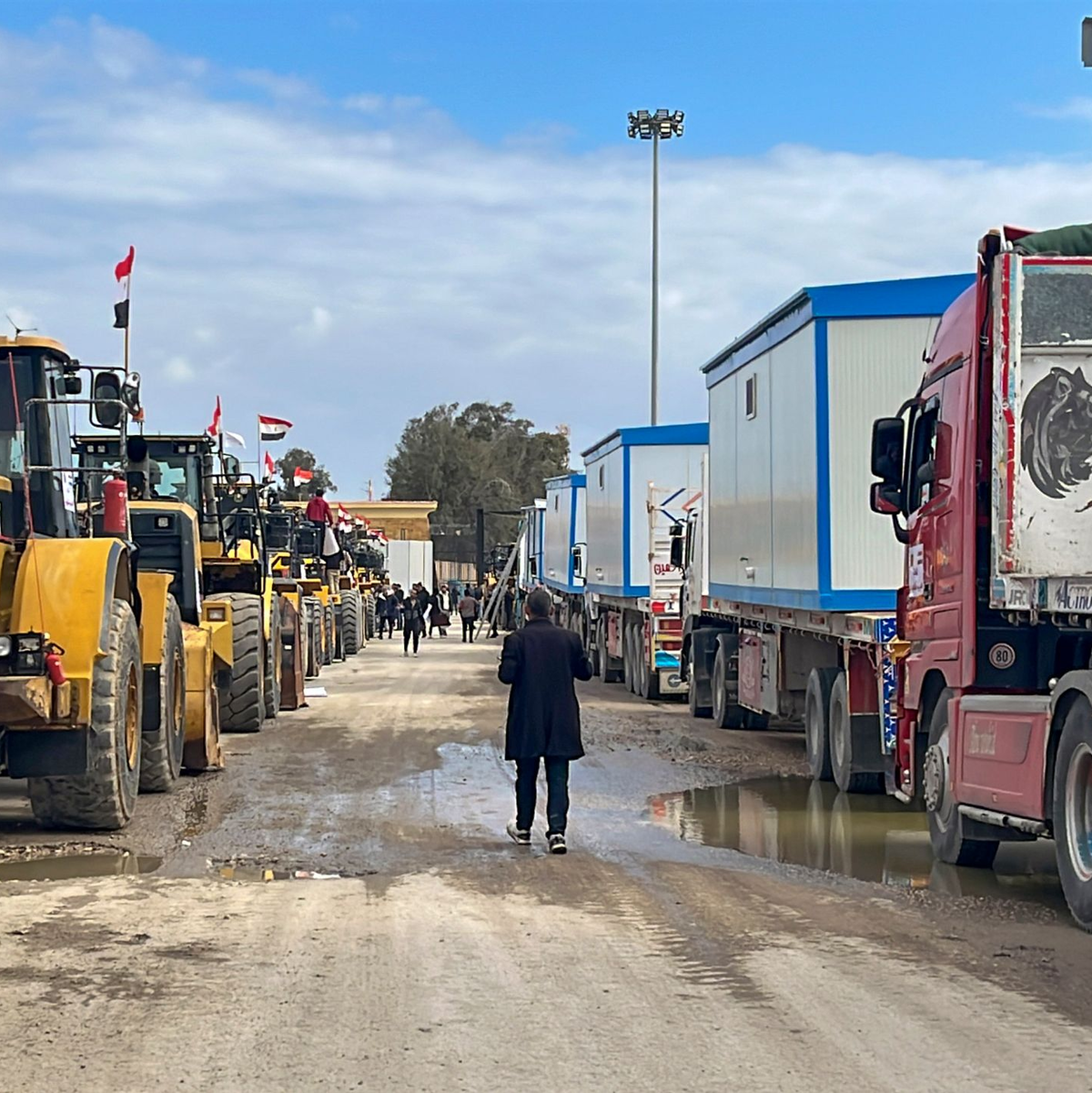 Bulldozer und Lastwagen mit Wohncontainern warten am Rafah-Grenzübergang. (Archivbild) - Foto: Mohamed Arafat/AP/dpa