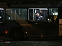 Ein Polizeibeamter inspiziert einen Bus.  - Foto: Ohad Zwigenberg/AP/dpa