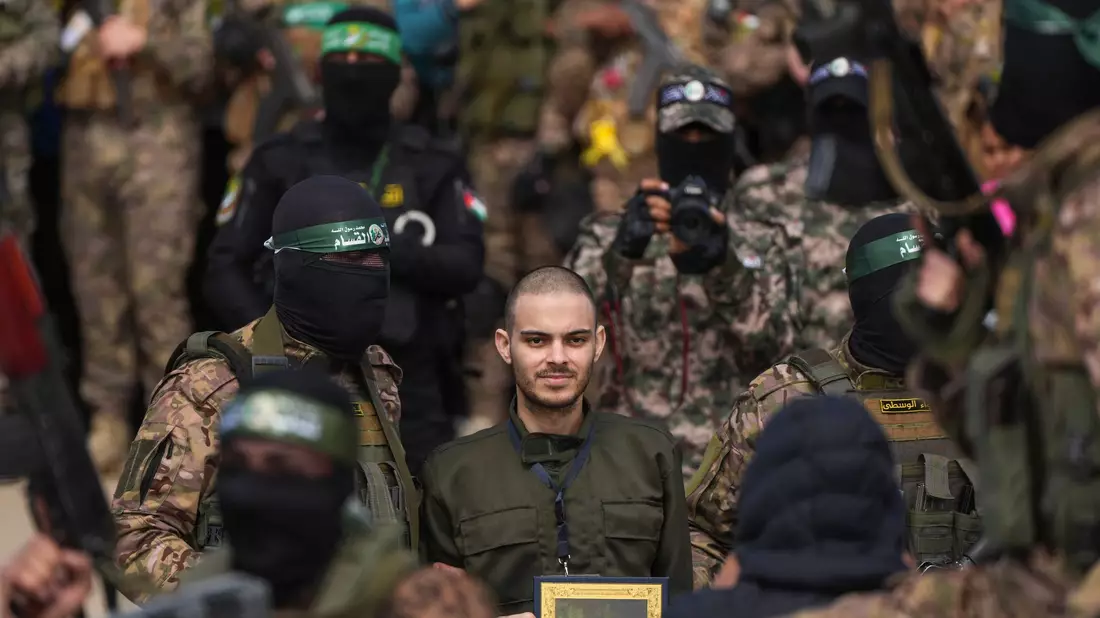 Eine Vertreterin des Roten Kreuzes spricht mit Hamas-Mitgliedern.  - Bild: Abdel Kareem Hana/AP/dpa