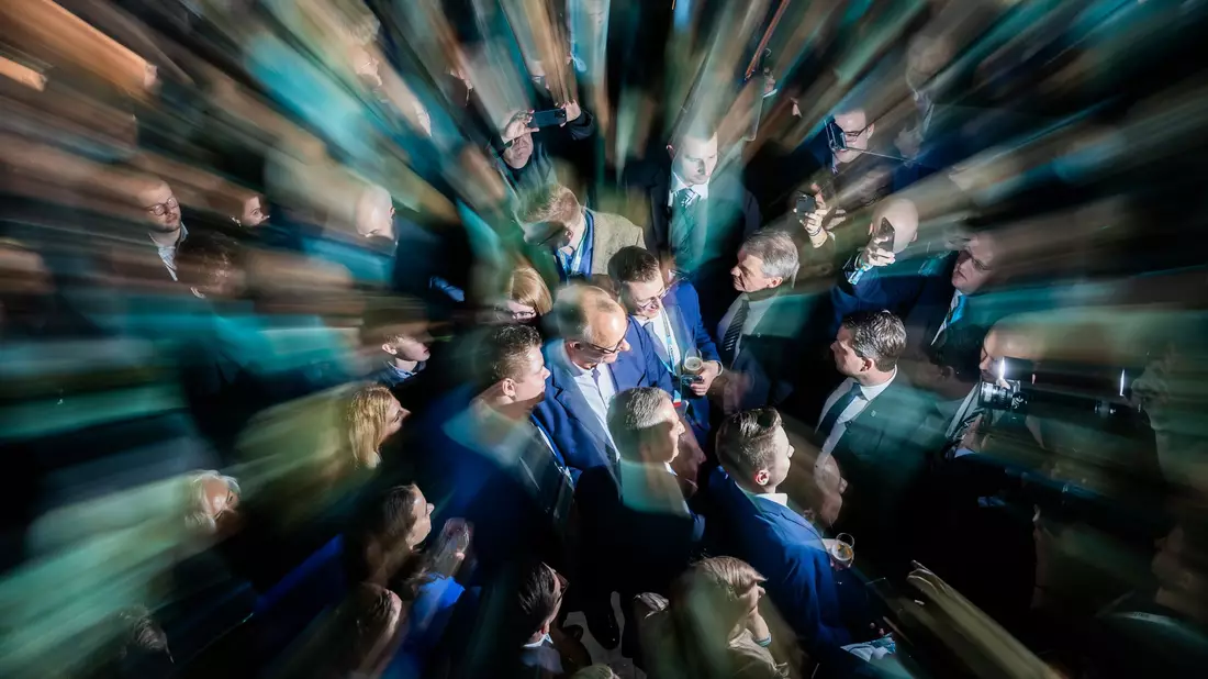Der Kanzlerkandidat der Union, Friedrich Merz, steht am Wahlabend zwischen Parteifreunden in der CDU-Parteizentrale. - Bild: Christoph Soeder/dpa