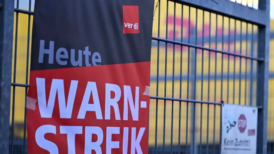 Ein Warnstreik-Plakat an einer DHL-Zustellbasis Ende Januar - an anderen Standorten des Bonner Logistikers wird nun erneut gestreikt. - Bild: Wolf von Dewitz/dpa