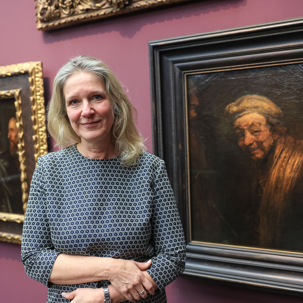 Anja Sevcik steht zwischen einem Selbstbildnis von Peter Paul Rubens unter Freunden (links) und einem Selbstbildnis von Rembrandt (rechts).  - Foto: Oliver Berg/dpa
