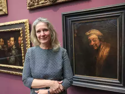 Anja Sevcik steht zwischen einem Selbstbildnis von Peter Paul Rubens unter Freunden (links) und einem Selbstbildnis von Rembrandt (rechts).  - Foto: Oliver Berg/dpa