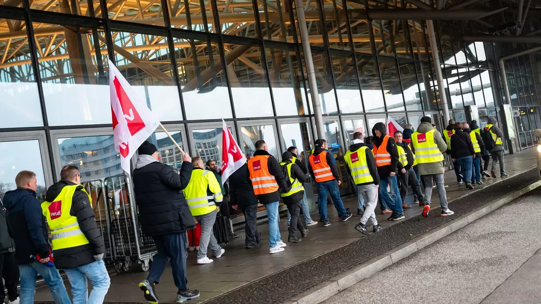 Streikende demonstrieren am Morgen am Flughafen Hamburg.  - Bild: Jonas Walzberg/dpa